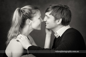 man and woman looking lovingly at each other smiling. Black and white photography. Relationship portraits studio in Melbourne