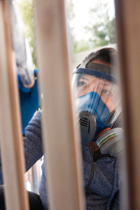 A woman painting the crib or cot for her newborn