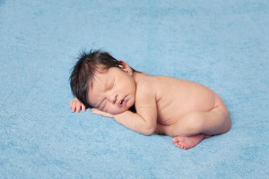 Newborn photography baby boy asleep on blue