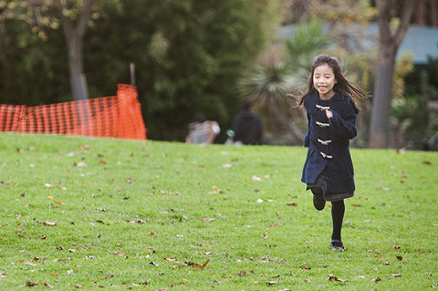 Happy girl running in park on grass
