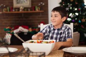 handsome boy at kitchen table with food at christmas