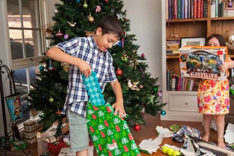 kids opening christmas presents with christmas tree and decorations