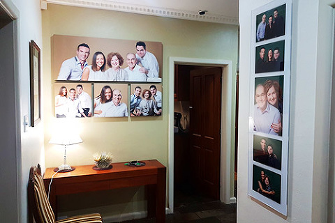 Family photos displayed designed on wall in entry way of home