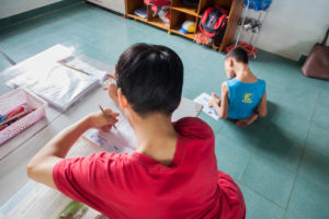 two boys with physical disabilities practicing their writing skills
