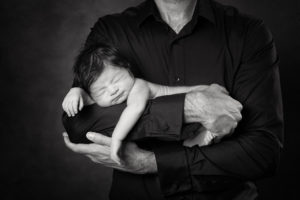 Natural newborn portrait photography Dad holding baby black and white