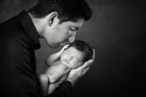 Natural newborn portrait photography Dad kissing baby