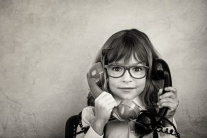 cute little girl holding two phones contact